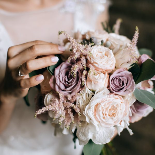 The bride holds a beautiful wedding bouquet of pink and white fl
